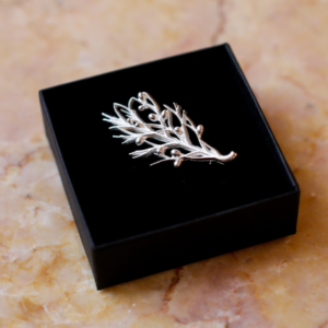 The Sterling silver juniper sprig, the badge of Guild membership.